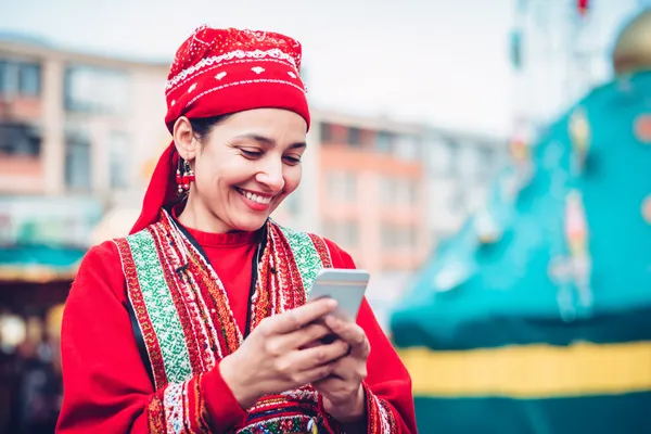 A young woman relaxing with her phone while dynamic casino elements float around her, illustrating the smooth mobile experience offered by the DEAWUN app.